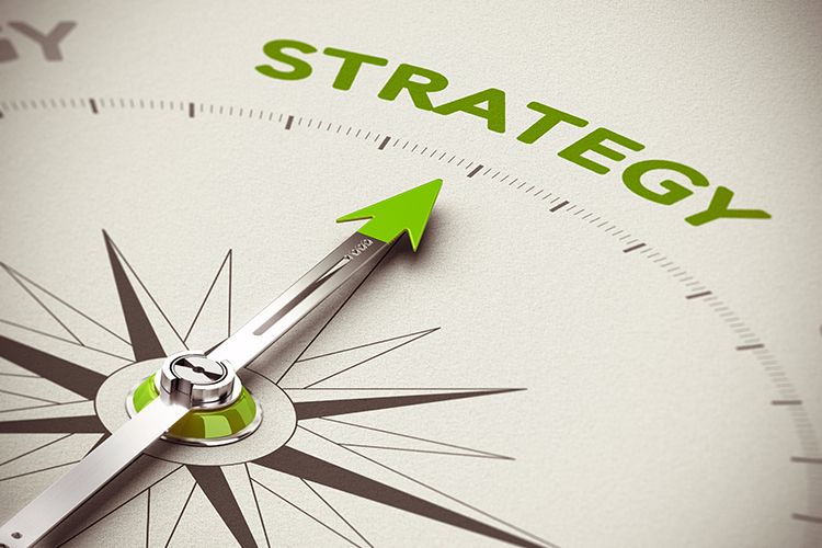 A compass with a green arrow pointing to the word strategy